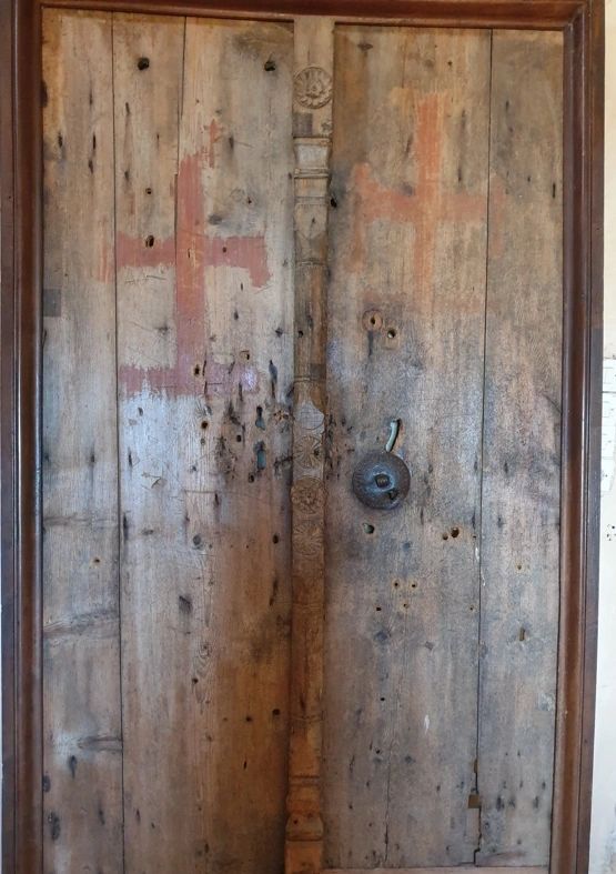 The old door, bullet and bayonet holes are still visible 